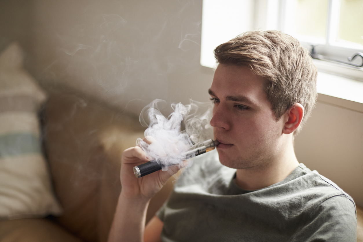 Young Man Using Vapourizer As Smoking Alternative